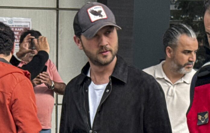 Aras Bulut İynemli, şapka ve siyah gömlekle görüntülenirken